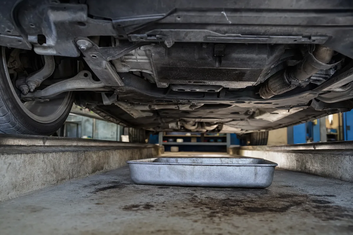 Voiture citadine stationnée de profil devant une maison en pierre du Sud-Ouest